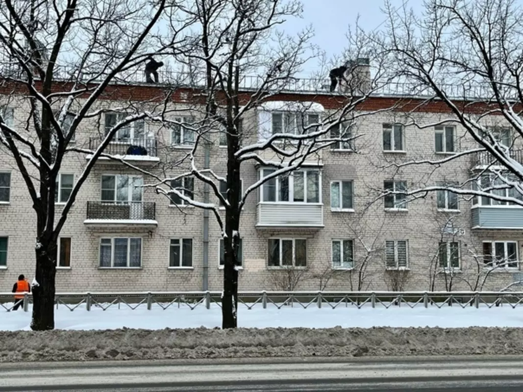 Производится уборка снега с крыш домов